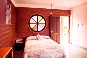 戈亚斯州上帕莱索Daya Ma Hospedagem的一间卧室设有一张床和一个圆形的窗户。