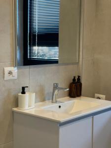 地拉那Square INN Garden Aparthotel的一间带水槽和镜子的浴室