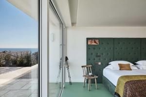 阿德莫尔崖屋酒店的一间卧室配有一张带绿色床头板的床