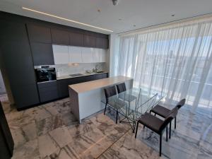 利马索尔Luxury Private Apartments - Limassol的厨房配有玻璃桌和一些椅子