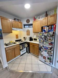 纽约Charming One-Bedroom Apartment in South Chelsea的厨房配有木制橱柜和冰箱。