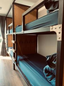 威廉堡Ben Nevis Inn Rooms的配有蓝色床单的客房内的两张双层床