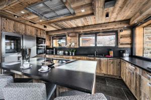 梅杰夫Chalet Lamartine - Chalets pour 12 Personnes 174的厨房设有大型黑色台面和木墙