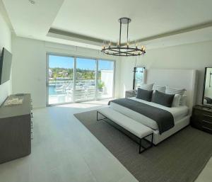 拿骚Palm Cay Marina and Resort的白色的卧室设有床和大窗户