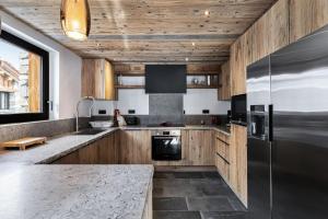 瓦勒迪泽尔Résidence La Tapia - Chalets pour 14 Personnes 364的厨房配有木制橱柜和不锈钢冰箱。