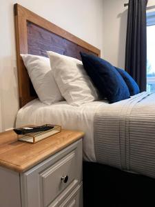 梅努斯53 Luxury Rooms的一张带蓝色和白色枕头的床和木制床头板