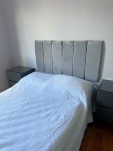 里约热内卢Magnífico apartamento的一间卧室配有白色床和2个床头柜