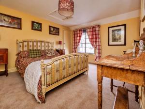 MattishallFinest Retreats - Lychgate Cottage的一间卧室配有一张床和一张书桌