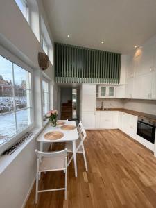 RosersbergEtt nytt fräsch hus utanför Stockholm nära Arlanda的厨房配有白色橱柜和桌椅