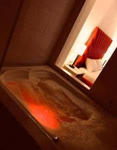 麦德林Hotel Opera, Centro Medellín, Entertainment,Y Bar, Solo Adultos的睡床旁的浴缸里装有红色液体