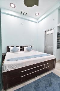 AyodhyaHotel Ramayan Inn Free Pickup From Ayodhya Dham Junction的一间卧室配有一张蓝色地毯的大床