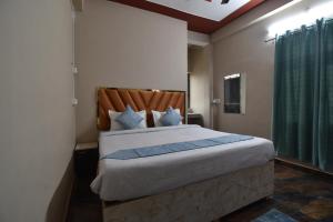 AyodhyaHotel Ramayan Inn Free Pickup From Ayodhya Dham Junction的一间卧室配有一张大床和木制床头板