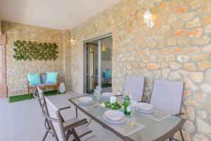埃尔加斯托尔3 bedrooms chalet with private pool terrace and wifi at El Gastor的一间设有桌椅和石墙的用餐室