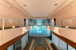 卢森堡Elegant 1BR Apt, Balcony, Pool, Central Location的一座带游泳池的建筑里一条空的走廊