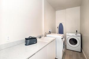 代托纳海滩Max Beach Resort的白色的浴室设有洗衣机和水槽。