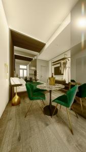 都灵5GreenLuxurieRooms的客厅配有绿色椅子和桌子