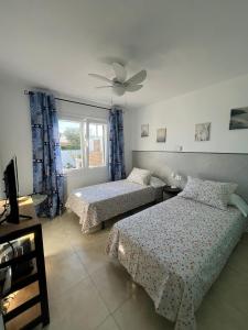 卡拉恩波特Tramontana Villa的一间卧室配有两张床和吊扇