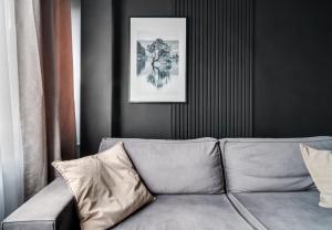 弗罗茨瓦夫BLACKNIGHT Apartment - Self Check-In 24h的客厅的沙发,墙上挂着一幅画