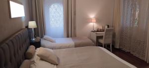 Buguggiate"La Selvetta" bed and breakfast的酒店客房配有两张床和一张书桌