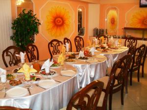 乌斯季卡缅诺戈尔斯克乌斯季卡缅诺戈尔斯克酒店的用餐室配有桌椅和食物