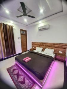 阿格拉Taj Street Hostel的一间卧室配有一张紫色照明的大床
