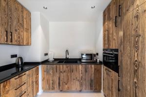 谷雪维尔Résidence Horizon Blanc - 4 Pièces pour 6 Personnes 314的一个带木制橱柜和水槽的厨房