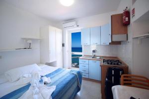 佩斯基奇Pensione La Torretta的一间卧室配有一张床,厨房享有海景