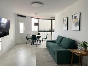 莫罗德哈布雷Jandia Beach Apartment 2的客厅配有绿色沙发和桌子