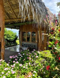 BalgueHostel & Camping Sol Y Luna Ometepe的一座花园,在一座建筑前种有鲜花