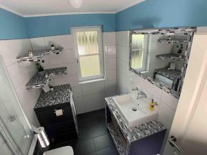 格拉尔-米里茨discovAIR Graal Müritz -Haus Quisisana- Strandnah mit Netflix的一间带水槽和镜子的浴室