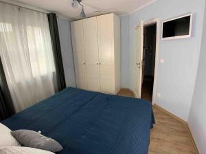 格拉尔-米里茨discovAIR Graal Müritz -Haus Quisisana- Strandnah mit Netflix的一间卧室配有一张蓝色的床和一个衣柜