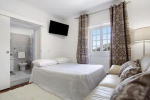 里韦拉布拉瓦Sea La Vie House的一间卧室配有一张床、一张沙发和一个窗口