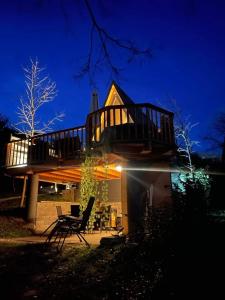 斯玛杰克托莱塞Glamping Holiday House with hot tub and sauna- Hisa oddiha的一座房子,上面有一个大甲板,晚上