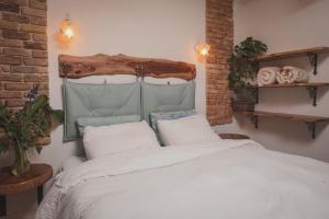 Bet Alfaחלון לגלבוע צימר בוטיק בעמק המעיינות的卧室配有白色的床和木制床头板