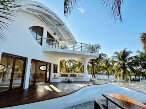 San CrisantoUnique Beachfront Casa Kyma, Pool, San Crisanto, Yucatan的海滩上带阳台的白色房屋