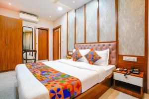 孟买Hotel Affari的一间卧室配有一张大床和色彩缤纷的毯子