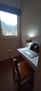 Madalena do MarLevadinha - Nature guest house的一张桌子上的笔记本电脑,窗户