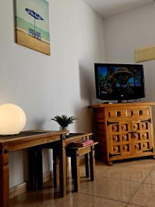 阿罗纳Las Americas Central Sun Appartament的客厅配有木桌和电视。