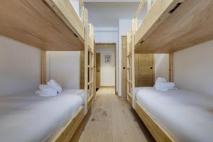 拉赫兹耶尔Résidence Les Alpages - Pièces 884的铺有木地板的客房内配有两张双层床。