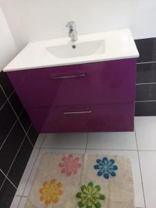 黑角Villa des fleurs的一间带紫色水槽和地毯的浴室