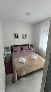 索科矿泉村Sunflower Apartmani的一间卧室配有一张大床和两条毛巾