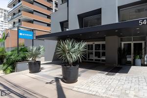 圣保罗Paulista Premium Flat的前面有三株盆栽植物的建筑