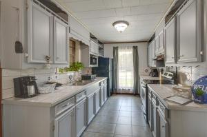 PrentissSilver Creek Getaway with Fireplace - 12 Mi to Lake的一间设有白色橱柜和瓷砖地板的大厨房