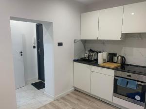 比托姆Apartament Piekarska Oficyna的厨房配有白色橱柜和炉灶烤箱。