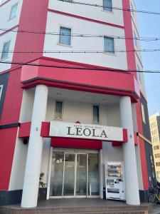 大阪HOTEL LEOLA - Vacation STAY 84059v的一座红白色的建筑,有利奥拉商店