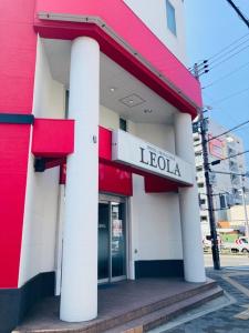 大阪HOTEL LEOLA - Vacation STAY 84059v的一座红色和白色的建筑,上面有标志