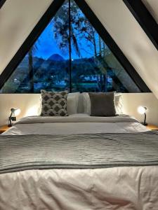 贾丁Avalon Hotel Campestre的一张位于带大窗户的房间内的床铺