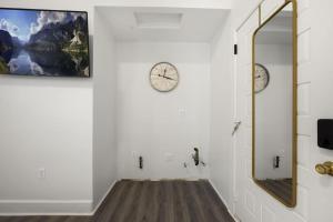 布鲁克林Bay Ridge Elegance: Luxe Hotel Getaway的走廊上墙上有两把钟,还有一面镜子