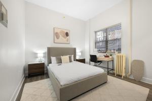 布鲁克林Bay Ridge Elegance: Luxe Hotel Getaway的一间卧室配有一张床、一张书桌和一个窗户。
