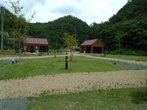 ShōbaraAyu no Sato Park Campsite - Vacation STAY 42240v的绿色的田野,有两栋建筑